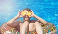 Cute sporty boy swims in the pool with donut ring and has fun, smiles, holds oranges. vacation with kids, holidays, Royalty Free Stock Photo