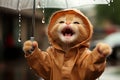 Cute standing kitten with white umbrella and brown raincoat, dripping raindrops