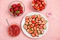 Cute strawberries in bowls and plates. Sliced, whole, and made into strawberry jam. Red berries on a pink tablecloth