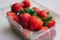 Cute strawberries in a plastic basket on a white background