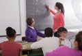 Cute student solves task near blackboard in classroom mathematics Royalty Free Stock Photo