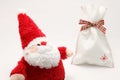 Cute stuffed toy Santa Claus and present on white background. Royalty Free Stock Photo