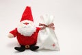 Cute stuffed toy Santa Claus and present on white background. Royalty Free Stock Photo