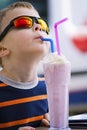 Stylish boy drinks a milkshake with ice cream Royalty Free Stock Photo
