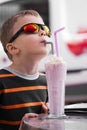 Stylish boy drinks a milkshake with ice cream Royalty Free Stock Photo