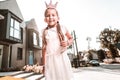 Cute stylish dark-eyed girl wearing white dress feeling funny