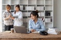 cute stylish female student, studying remotely from home, using a laptop, taking notes on notepad during online lesson Royalty Free Stock Photo