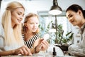 Cute stylish girl helping her mother to choose color of shellac