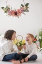 Cute stylish toddler child and older brother, boys with white shirt, playing with eggs and chocolate bunny on Easter decoration Royalty Free Stock Photo