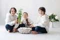 Cute stylish toddler child and older brother, boys with white shirt, playing with eggs and chocolate bunny on Easter decoration Royalty Free Stock Photo