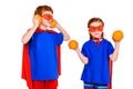 cute super children in masks and cloaks holding oranges