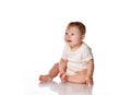 Cute surprised baby girl sitting on studio floor Royalty Free Stock Photo