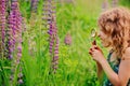 Cute surprised child girl exploring nature with loupe on summer field Royalty Free Stock Photo