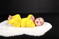 Surprised and curious baby boy lying on back on white fur Royalty Free Stock Photo