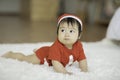 Cute Sweet Adorable Asian Baby wearing Santa hat and cloth costume lying on white carpet Royalty Free Stock Photo
