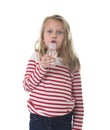 Cute sweet little girl with blue eyes and blond hair 7 years old holding bottle of water drinking Royalty Free Stock Photo