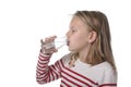 Cute sweet little girl with blue eyes and blond hair 7 years old holding bottle of water drinking Royalty Free Stock Photo