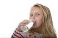 Cute sweet little girl with blue eyes and blond hair 7 years old holding bottle of water drinking Royalty Free Stock Photo