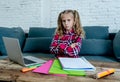 Cute sweet sad and overwhelmed blonde hair primary school girl looking angry bored and tired in stress with homework and studying Royalty Free Stock Photo