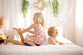 Cute sweet toddler children, tickling feet on the bed, laughing and smiling