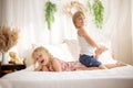 Cute sweet toddler children, tickling feet on the bed, laughing and smiling