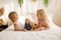 Cute sweet toddler children, tickling feet on the bed, laughing and smiling Royalty Free Stock Photo