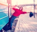 Cute sympathetic beautiful smiling young woman in hat rides on stairs outside train. extreme, danger, pleasure, drive, thrill, Royalty Free Stock Photo