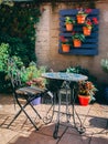 Cute table and chair with flower pots hanging on blue wood background