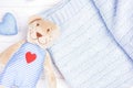 Cute teddy bear with red heart and blue knitting warm blanket Royalty Free Stock Photo