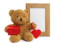 Cute teddy bear with red heart, gift box and frame on white background. Valentine`s day celebration Royalty Free Stock Photo