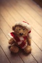 Cute teddy bear in santa claus hat on the wonderful brown wooden Royalty Free Stock Photo