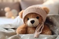 Cute teddy bear in warm hat on bed, closeup