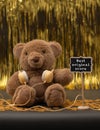 Cute teddy bear with yellow headphones, little chalkboard with `Best original score` written with white chalk Royalty Free Stock Photo
