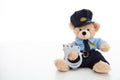 Cute teddy in policeman uniform and handcuffs against white background