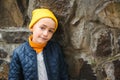 Cute teen boy close up portrait. Stylish boy wearing yellow hat and jacket. Autumn fashion, copy space. Outdoors portrait of cute