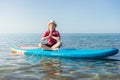 Cute child girl having fun and making yoga on sup board in Baltic sea Royalty Free Stock Photo