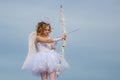 Cute teen cupid on the cloud - sky background. Valentines day. Lovely child. Concept of Valentines Daygirl dressed as an
