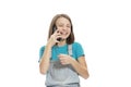 Cute teen girl in denim overalls talking on the phone and laughing. Isolated on a white background Royalty Free Stock Photo