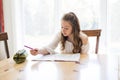 Cute teen girl doing homework at home