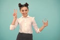 Cute teen girl drinking water from glass on blue background. Daily life health. Drink water for health care and body Royalty Free Stock Photo