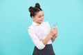 Cute teen girl drinking water from glass on blue background. Daily life health. Drink water for health care and body Royalty Free Stock Photo