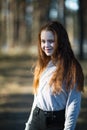 Cute teen girl with fiery red hair in the pine park Royalty Free Stock Photo