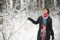 Cute teen girl having fun on a walk in snow covered pine forest on chilly winter day. Teenage child exploring nature Royalty Free Stock Photo