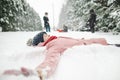 Cute teen girl having fun on a walk in snow covered pine forest on chilly winter day. Teenage child exploring nature Royalty Free Stock Photo