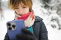 Cute teen girl having fun on a walk in snow covered pine forest on chilly winter day. Teenage child exploring nature Royalty Free Stock Photo