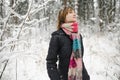 Cute teen girl having fun on a walk in snow covered pine forest on chilly winter day. Teenage child exploring nature Royalty Free Stock Photo