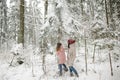 Cute teen girl and her mother having fun on a walk in snow covered pine forest on chilly winter day. Teenage child exploring Royalty Free Stock Photo