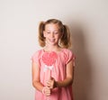 Beautiful little girl holding a big heart shaped lollipop Royalty Free Stock Photo