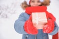 cute teen girl holding out a gift box, christmas present, outdoor in winter Royalty Free Stock Photo