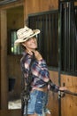 Cute teen girl in horse riding attire poses in barn Royalty Free Stock Photo